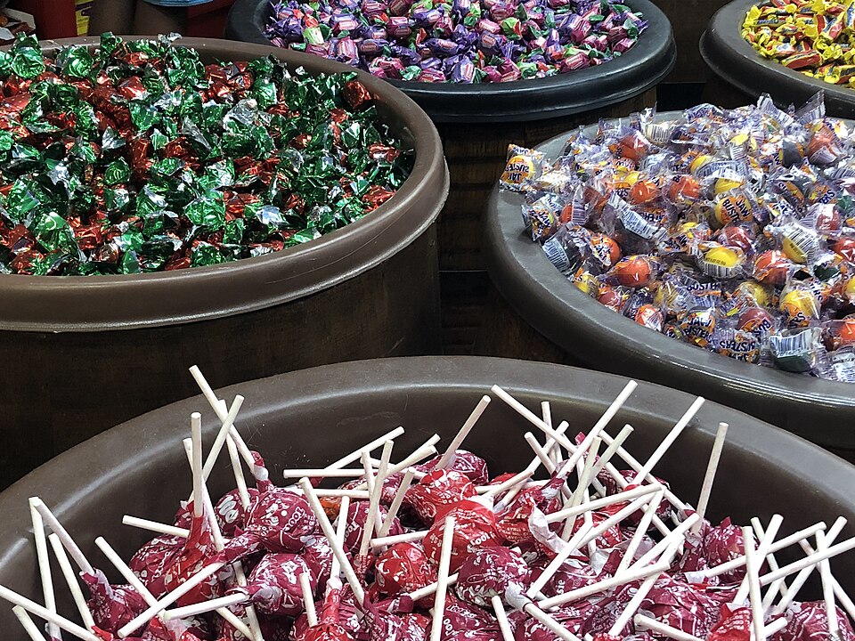 Wooden barrels of candy containing lollipops, strawberry bon-bons, and jawbreakers
